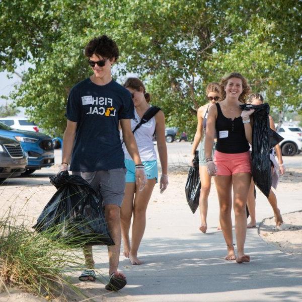 Student volunteers clean up a beach