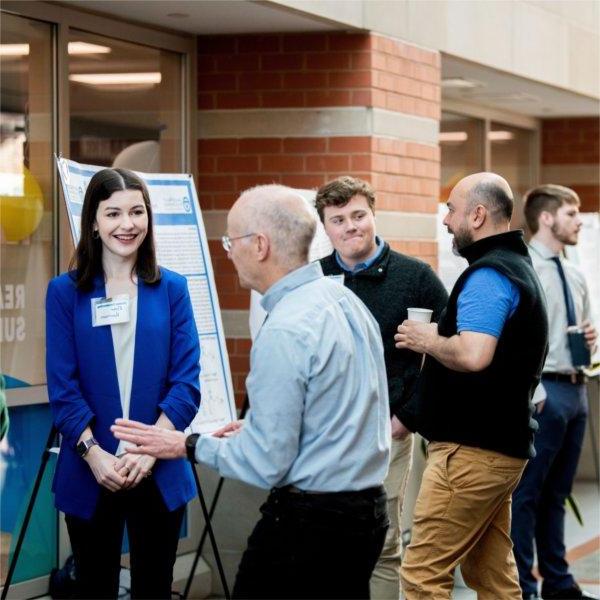 Students discuss their research with faculty members during Student Scholars Day